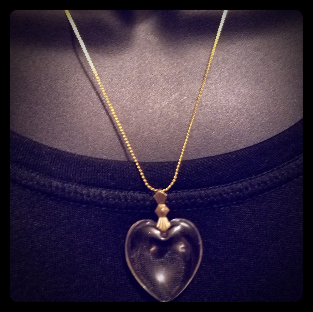 18in gold tone chain with a glass clear type heart
